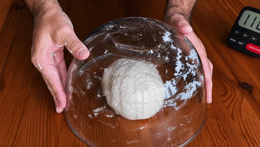 Masa de pizza napolitana reposando tapada con el bol