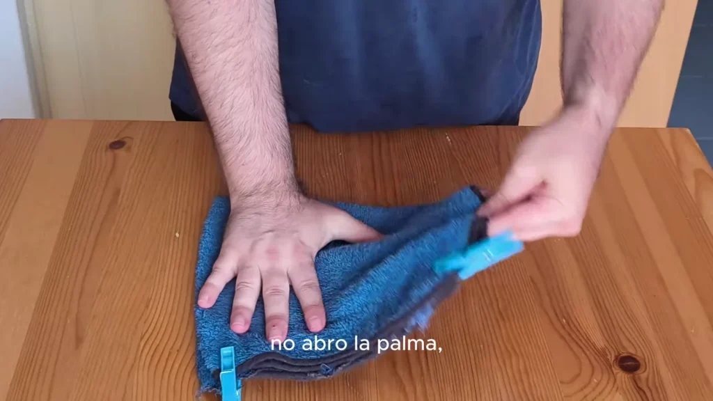 Mano con la palma semicerrada dejando pasar el trapo hacia el antebrazo durante el schiaffo