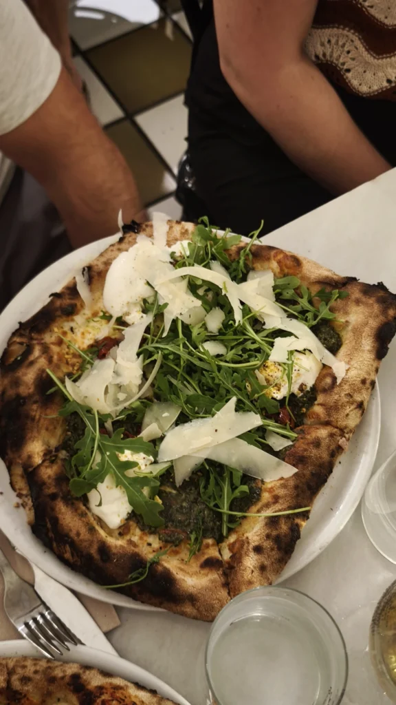 Pizza de pesto con burrata, rúcula, parmesano y pistachos