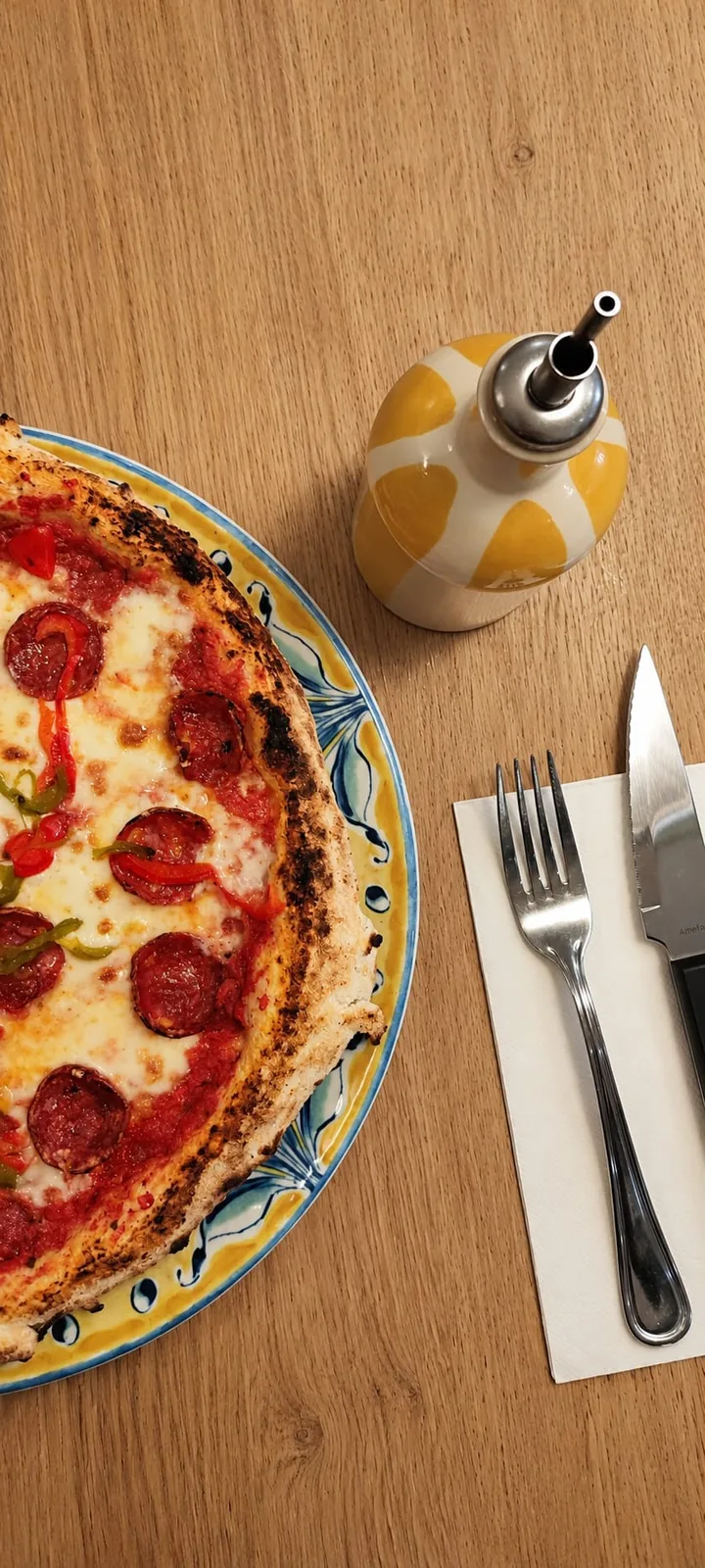 Pizza Peppe de Loujo Biarritz junto a una aceitera